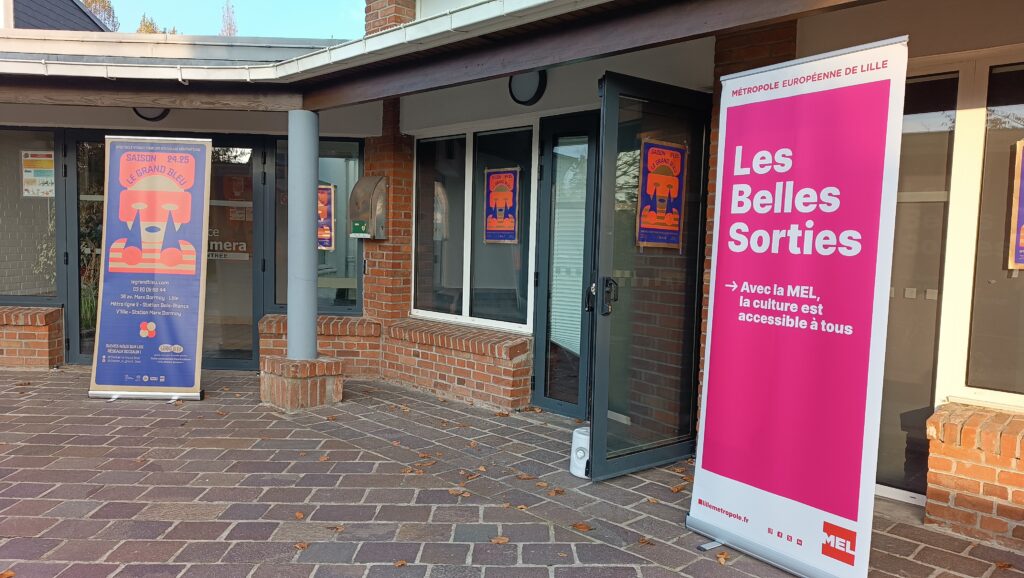 Extérieur d'une salle de spectacle avec les affiches du Grand Bleu et du dispositif Les Belles Sorties.